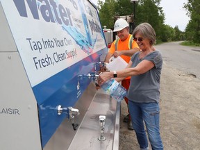 City employee Dan Friel helps Ilona Daggett fill her containers with water at the City of Greater Sudbury's Water Buggy on Old Skead Road in Garson, Ont. on Friday June 3, 2022. A drinking water advisory for the area has been lifted.