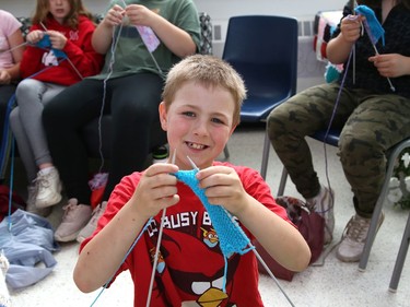 Connor Lacaille, 9, demonstrates his new skills he learned while participating in the Knitting Club at Chelmsford Valley District Composite School in Chelmsford, Ont. on Wednesday June 15, 2022. More than 30 elementary school students from the school have been working on their knitting skills before classes start in the morning and during recess, and at the same time, contributing to knitted blankets for cancer patients at the Northeast Cancer Centre. The Knitting Club students, lead by teacher Francine Portelance, presented four blankets to Tannys Laughren, lead of Volunteer Services at Health Sciences North. John Lappa/Sudbury Star/Postmedia Network