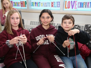 Emma Wilie, 11, left, Sophia Aguiar, 11, and Denver Aguiar, 9, demonstrate their new skills they learned while participating in the Knitting Club at Chelmsford Valley District Composite School in Chelmsford, Ont. on Wednesday June 15, 2022. More than 30 elementary school students from the school have been working on their knitting skills before classes start in the morning and during recess, and at the same time, contributing to knitted blankets for cancer patients at the Northeast Cancer Centre. The Knitting Club students, lead by teacher Francine Portelance, presented four blankets to Tannys Laughren, lead of Volunteer Services at Health Sciences North. John Lappa/Sudbury Star/Postmedia Network