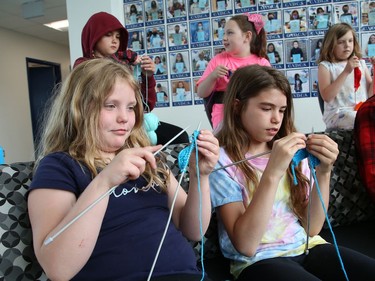Alicia Golder, 9, left, and Chloe Marshall, 10, demonstrate their new skills they obtained while taking part in the Knitting Club at Chelmsford Valley District Composite School in Chelmsford, Ont. on Wednesday June 15, 2022. More than 30 elementary school students from the school have been working on their knitting skills before classes start in the morning and during recess, and at the same time, contributing to knitted blankets for cancer patients at the Northeast Cancer Centre. The Knitting Club students, lead by teacher Francine Portelance, presented four blankets to Tannys Laughren, lead of Volunteer Services at Health Sciences North. John Lappa/Sudbury Star/Postmedia Network