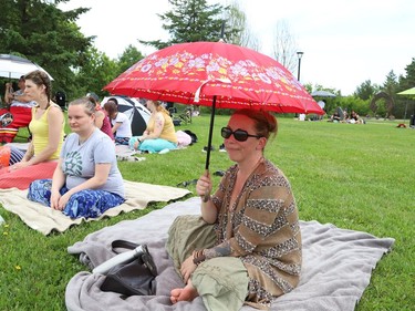 Jody Winn uses an umbrella to protect herself from the sun while attending a pow wow event to celebrate National Indigenous Peoples Day at Bell Park in Sudbury, Ont. on Tuesday June 21, 2022. John Lappa/Sudbury Star/Postmedia Network