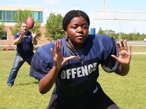 St. Benedict Catholic Secondary School student Khimberly Williams, 15, works on her game with her high school football coach, Junior Labrosse, at the school in Sudbury, Ont. on Wednesday June 22, 2022. Williams has been selected to play with Team Ontario U18. John Lappa/Sudbury Star/Postmedia Network