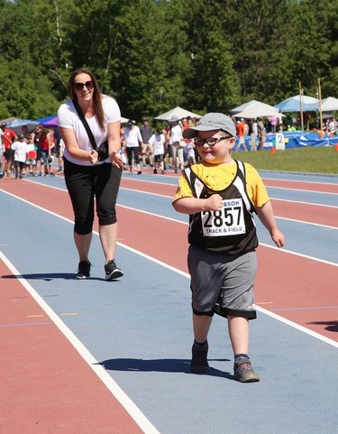 Nash Parcey, 6, of MacLeod Public School, participates in a 25 metre run while being encouraged by vice-principal Shannon Lafrance at the Rainbow District School Board Challenge Meet at Laurentian Community Track Complex in Sudbury, Ont. on Thursday June 23, 2022. About 330 students with special needs from 22 Rainbow schools participated in a variety of track and field events, including races, high jump, long jump, softball throw and shot put. John Lappa/Sudbury Star/Postmedia Network