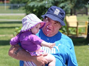 Rod Rienguette and his granddaughter, Lenna, 15 months, play at the splash pad in Coniston, Ont. on Friday June 24, 2022. John Lappa/Sudbury Star/Postmedia Network