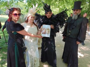 Attendees to the 2022 Wave Gotik Treffen Music Festival in Leipzig, Germany hold up a picture of the late Jennifer Ellis, sister of Petrolia author and entrepreneur Dawn Stillwell.  Handout/Sarnia This Week