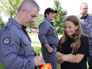 Aria Thomson gets her paper torch signed by a member of the Institutional Crisis Intervention Team from Monteith Correctional Complex at the Law Enforcement Torch Run. The event raises funds and awareness for the Special Olympics, for people with intellectual disabilities.

NICOLE STOFFMAN/The Daily Press