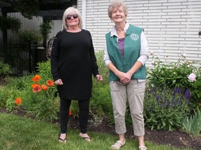Carol Ritchie (right) from the Paris Horticultural Society greeted guests at the home of Dawn Barber (left) in Paris Sunday during the annual two-day Paris Garden Tour. There were six homes on the tour this year. CHRIS ABBOTT