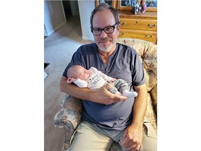 Paul Totten, 54, of Woodstock, is being remembered by his daughters as a hardworking and humorous animal lover who deeply cared for others. He is holding his granddaughter Luna. Totten died Monday after a fall from a ladder while working for Bell Canada in Tillsonburg. (Submitted photo)