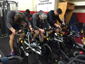 Members of the 2016 Owen Sound Attack ride the bikes inside the team's training facilities at the Harry Lumley Bayshore Community Centre. The Hockey FIT program helps to improve the health and lifestyles of hockey fans through engaging training programs geared to sport-specific training methods and teamwork. Photo from Attack Hockey.