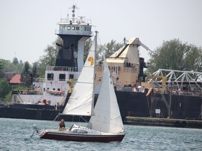 A sailboat passes by a freighter entering the Soo Locks in Sault Ste. Marie, Mich., on Monday, May 30, 2022. (BRIAN KELLY/THE SAULT STAR/POSTMEDIA NETWORK)