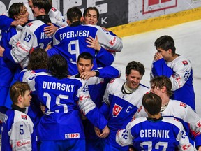 Sudbury Wolves import draft picks Jakub Chromiak, centre, and Dalibor Dvorsky embrace as they and their teammates celebrate Slovakia's win at the 2022 IIHF World Men's Under-18 Division IA championship.