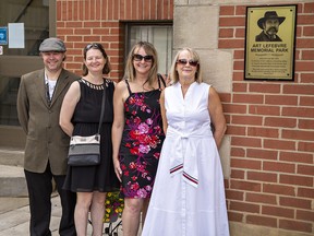 Aidan Lefebvre (left), his sisters Celeste and Renee, and mother Dianne stand beside a plaque unveiled on Wednesday morning at a dedication of Art Lefebvre Memorial Park on Pearl Street in Brantford, Ontario.