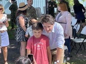 Prime Minister Justin Trudeau poses for photos with family members of Canadian Forces personnel at 22 Wing/CFB North Bay on Wednesday.