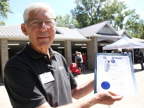 Kiwanis eastern Canada and Caribbean district governor Jim Scott poses with a certificate and pin for a Kiwanis member Saturday, outside the Seaway Kiwanis Pavilion in Canatara Park. Scott was on hand in Sarnia to award Legion of Honour recognitions to 30 members from six regional clubs. (Tyler Kula/ The Observer)