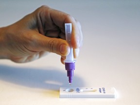 A person squeezes a drop of testing solution into a COVID-19 rapid antigen testing device. Local cases are increasing amid Ontario's seventh wave of the pandemic.