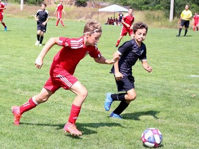 Joshua Rioux, left, of the GSSC Impact pursues the ball while under pressure from a Barrie Spirit defender during Huronia District Soccer League boys under-13 action at Delki Dozzi Park in Sudbury,  Ontario on Saturday, July 9, 2022.