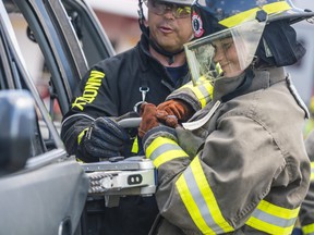 A Camp Molly student uses a Jaws of Life spreader tool to pry open a minivan door as she participates in the first-day activities at the camp aimed at teaching young women the skills needed to be a Firefighter. ALEX FILIPE