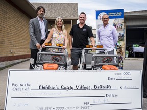 From left, Bill Glisky, executive director for Children's Safety Village, Jill Raycroft, CEO at the Belleville Chamber of Commerce, John-Ross Parks, Royal LePage ProAlliance Realty Brokerage and Matt Howell, Children's Safety Village chair, stand alongside two electric jeeps and a cheque for $2,000. ALEX FILIPE
