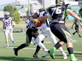 Paolo Grossi (25) of the Sudbury Junior Spartans tries to break past a couple of tackles while returning a punt during Ontario Summer Football League action at James Jerome Sports Complex in Sudbury, Ontario on Saturday, July 16, 2022.