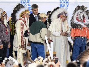 Pope Francis wears a headdress presented to him by Indigenous leaders during a meeting at Muskwa Park in Maskwacis, Alberta on July 25. PATRICK T. FALLON/AFP via Getty Images