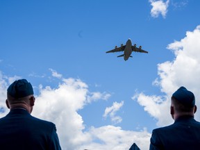 Two members of the RCAF witness a flyover being performed by a CC-177 Globemaster aircraft during 8 Wing Trenton's Change of Command ceremony on Friday in Trenton, Ontario. ALEX FILIPE