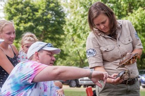 John Noes of St. Marys has a conversation with Krystal Hewett, a wildlife educator from Speaking of Wildlife, during a presentation at Wildwood Conservation Area on Sunday.  Chris Montanini/Stratford Beacon Herald