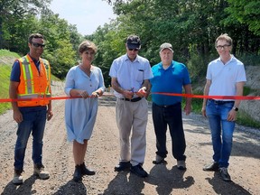 Dutton Dunwich Deputy Mayor Mike Hentz (middle) prepares to cut the ribbon marking the completion of the Ash Line project and reopening of the section of the road. From left are: Matt Cassidy of Cassidy Construction, MP Karen Vecchio, Hentz, Coun. Ken Loveland, and John Spriet of Spriet Associates. Victoria Acres