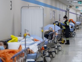 Paramedics transfer patients to the emergency room triage at a hospital in Toronto on Tuesday, January 25, 2022. THE CANADIAN PRESS/Nathan Denette