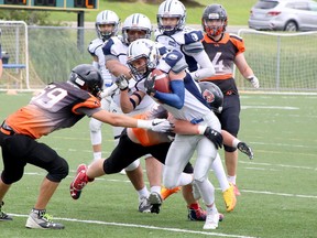 Sudbury Junior Spartans ball-carrier Carson Huzij (7) is tackled by a group of Peterborough Wolverines players during an Ontario Summer Football League semifinal at James Jerome Sports Complex in Sudbury, Ontario on Saturday, July 30, 2022.