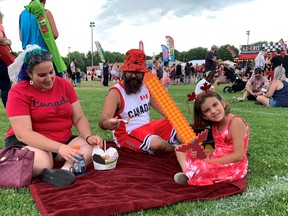There were long lineups at numerous food trucks Friday as many picnicked on snacks and lunches at Brantford's celebration. Decked out in their Canada garb, Stephanie Brown, left, Kyle Saunders and Amelia Saunders shared a very Canadian poutine snack.
