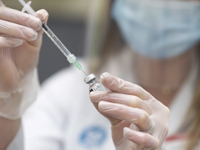 Pharmacist Alison Davison prepares a dose of Pfizer-BioNTech COVID-19 vaccine at Shoppers Drug Mart pharmacy on 17 Ave. S.W. in Calgary on March 5, 2021. AZIN GHAFFARI /Postmedia