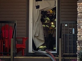 Fire fighters exit the Coopers Crossing residence through a smoke curtain as they respond to the fire that broke out on June 27. Photo courtesy of the City of Airdrie/Airdrie Fire Department