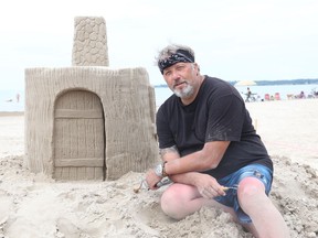 Professional sand sculptor is pictured with a castle he built for demonstration during Sandfest at Sandbanks Provincial Park Wednesday morning. BRUCE BELL