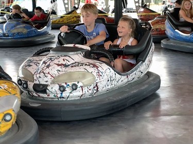 Josh Travers, 12, drove Quinn Gurd, 6, in the bumper cars that were one the many midway rides attracting hundreds at Brantford's Canada Day event on Friday. Susan Gamble