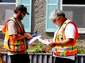 Ontario Land Surveyors John Monahan, left, and Rob Wannack, of IN Engineering and Surveying, converse Friday morning in front of the Market Street West building the company is studying as part of efforts to save it from demolition. (RONALD ZAJAC/The Recorder and Times)