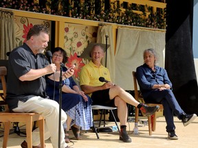 From left, Craig Walker, a director and actor with the St. Lawrence Shakespeare Festival over many seasons, reads a note from former festival artistic director Rona Waddington while hosting a panel discussion with festival founder Deborah Smith, former artistic director Ian Farthing and current artistic director Richard Sheridan Willis at the Kinsmen Amphitheatre in Prescott on Saturday. (RONALD ZAJAC/The Recorder and Times)