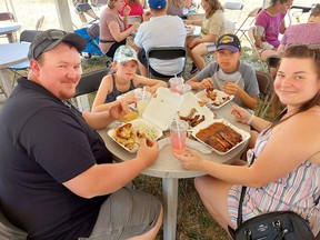 Mike Guyett, left, of Dealtown, is seen here enjoying some great food at Chatham-Kent Ribfest on Saturday with his daughter Addisyn, 9, son Keegan, 12, and wife Courtney. PHOTO Ellwood Shreve/Chatham Daily News
