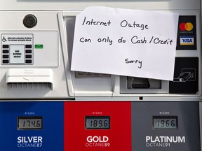 Signs posted on gas station pumps indicate cash is the only acceptable payment method due to the nationwide Rogers internet outage on Friday.