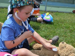 Huxley Girard checking to see if his teddy needs medical attention during the picnic on Wednesday July 27, 2022 in Ingleside, Ont. Shawna O'Neill/Cornwall Standard-Freeholder/Postmedia Network
