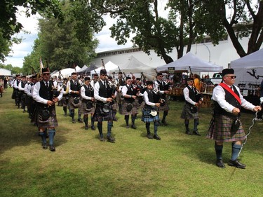 A pipe band makes its way along a grassy pathway behind the grandstand, on the first day of the 73rd edition of the Glengarry Highland Games. Photo on Friday, July 29, 2022, in Maxville, Ont. Todd Hambleton/Cornwall Standard-Freeholder/Postmedia Network