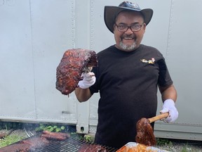 Jorge Gonzalez puts the finishing touches on a couple racks of ribs ahead of the London Ribfest and Craft Beer festival, which runs Thursday through Monday at Victoria Park. (JOE BELANGER/The London Free Press)