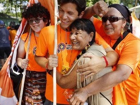 Jasmine Nutseniu Ishkuess, from left, her brother Jay Launiere-Methias, their grandmother, Therese Telesh Begin, and their mother, Sandra Launiere, embrace after completing a 275-kilometre march from their Mashteuiatsh reserve to Quebec, coinciding with the visit by Pope Francis on the Plains of Abraham on Wednesday in Quebec. Pope Francis is travelling across Canada for a "pilgrimage of penance," to meet with and apologize to Indigenous communities for the abuse at the schools.