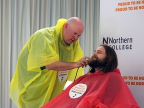 Drew Enouy shaves off the beard of Brandon Brough during the Beards off for Bursary fundraising event. Photo courtesy of Northern College