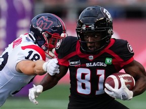 Ottawa Redblacks wide receiver Terry Williams (81) runs the ball as Montreal Alouettes safety Zach Lindley (18) defends during the first-half CFL action in Ottawa on Thursday, July 21, 2022. (THE CANADIAN PRESS/Sean Kilpatrick)