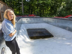 Krista Peters of Strathroy stands in her partially built pool, courtesy of a new installer after her original pool installation guy left her with nothing but debts and a huge hole in the ground behind their home. Mike Hensen/Postmedia