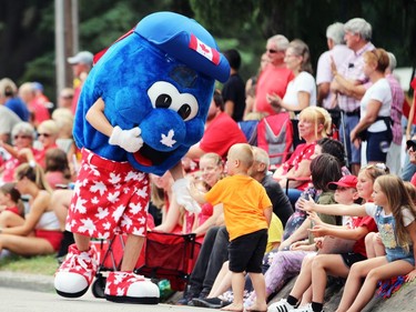 A boy gets a high five from a mascot during Sarnia's Canada Day parade on Friday. Terry Bridge/Sarnia Observer/Postmedia Network