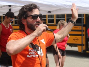 Paul Skuza, with the YMCA in Sarnia, welcomes teams Friday to a fundraiser where they pushed a school bus to support the Fill the Bus campaign to help send kids to the Y's summer day camps.