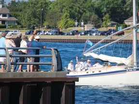 A sailboat on the St. Clair River heads for Lake Huron near Point Edward Saturday for the start of the annual Port Huron to Mackinac Island sailboat race.  Spectators watch from a lookout below the Blue Water Bridge.