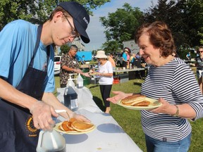 Volunteer Doug Thibert delivers syrup for Claudia Miller at the Sarnia Rotary Club Mackinac Breakfast Saturday in Point Edward's Waterfront Park.