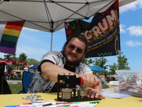 Zibby Blanchard makes buttons at the Rebound Spectrum tent Saturday for visitors to Sarnia-Lambton Pridefest in Sarnia's Centennial Park.